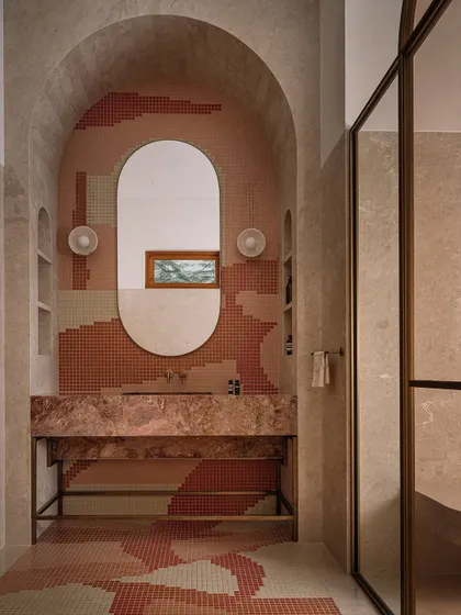 A full view of the parent's bathroom, where the mosaic pattern flows from the floor up the wall, creating an immersive and artful experience.