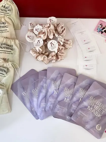 Assembling our bridesmaid thank you kits. This includes our popular "I Regret Nothing" hangover recovery kits, bubble sheet masks, satin scrunchies, and fun "Advice for the Bride" cards.