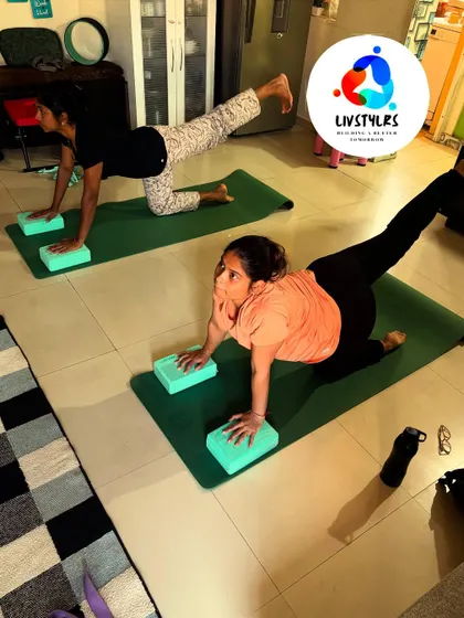 Two clients perform a bird-dog pose on blocks, an exercise that enhances core stability and balance.