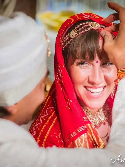 The sacred moment of applying the sindoor. The bride's joyful smile as her husband performs the ritual is a memory to be cherished forever.