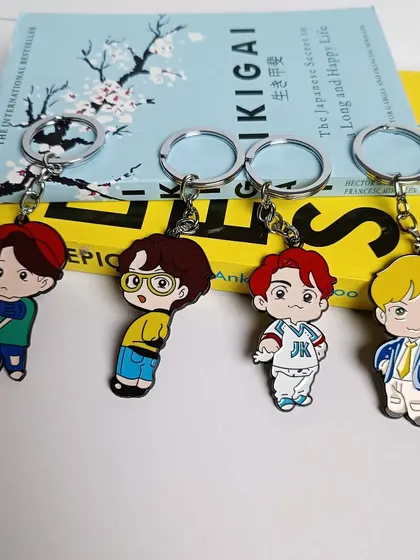 A close-up of the Jungkook, V, Jin, and Suga keychains from the BTS collection.