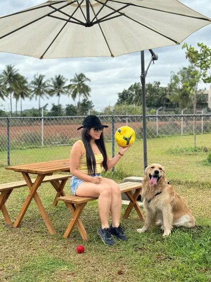 A lovely photo of a pet parent with her happy golden retriever, ready for a day of play.
