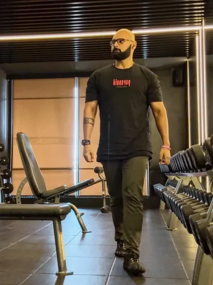 Walking through the dumbbell rack, in the zone. Routine and discipline are the cornerstones of a successful fitness journey.