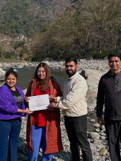 Celebrating the completion of a transformative journey. We honor each participant's commitment with a certificate of completion, presented here against the beautiful, rugged landscape of our Rishikesh retreat location.