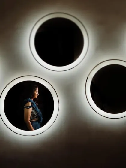 An artistic bridal portrait using circular mirrors for a unique framing effect. This creative composition results in a modern and memorable image.