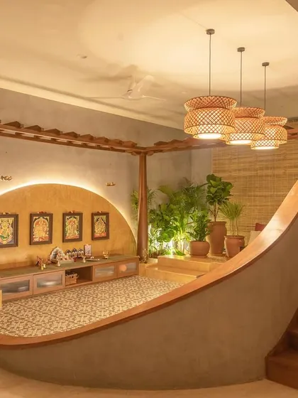 This modern puja room is designed as a tranquil, sacred space within the home. The curved, sunken seating area, warm backlighting, and traditional floor tiles create a serene spot for prayer and reflection.