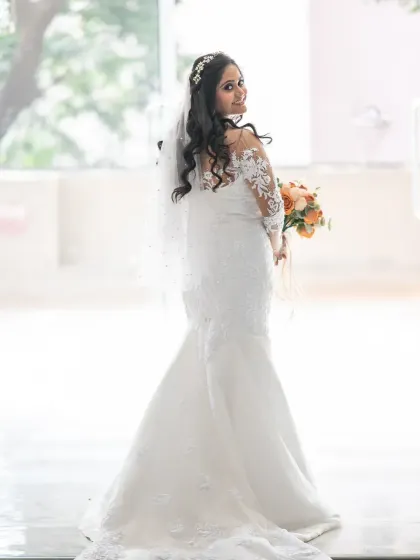 A lovely bridal portrait with a bright, happy feel. The bride's glance over her shoulder and her smile create a charming and candid-style photo.