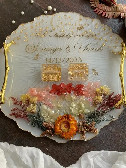 A beautiful engagement ring platter with preserved flowers, gold handles, and personalized text. A perfect centerpiece for your ring ceremony.