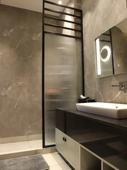 Another view of the master bathroom, highlighting the curved ceiling detail and the spacious, functional layout.