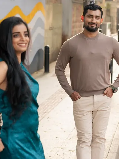 Capturing a candid smile as they explore the city streets together. The golden light and casual poses make this feel like a snapshot from their personal love story.