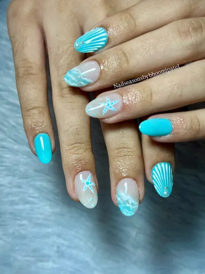 The combination of solid turquoise nails and detailed accent nails creates a balanced and fun look.