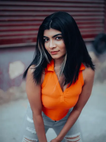 A full-length shot of a model in a casual outfit. The urban background and her relaxed pose are perfect for a street style portfolio.
