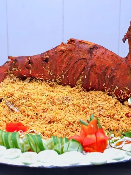 A whole roasted mutton shaped like a camel, served on a bed of biryani. This is an example of the creative presentation we can do for your event.
