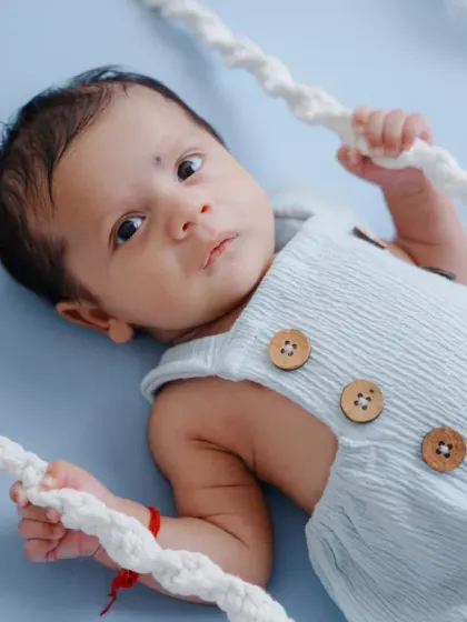 This alert newborn is enjoying his time on the cloud-themed swing, looking right at the camera with his big, beautiful eyes.