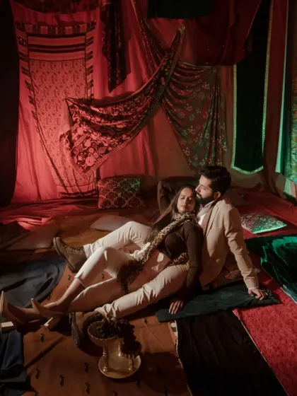 An intimate moment from one of our stylized indoor shoots, using warm lighting and rich textiles to create a cozy, romantic ambiance. This demonstrates our versatility in crafting beautiful narratives within a controlled studio environment.
