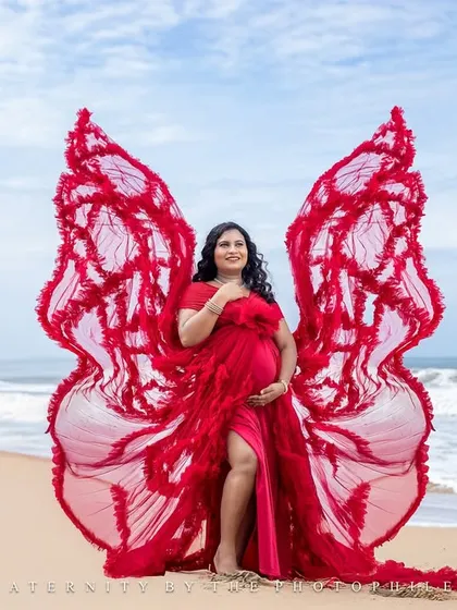 The butterfly wings of the red gown are on full display in this powerful and artistic shot against the ocean.