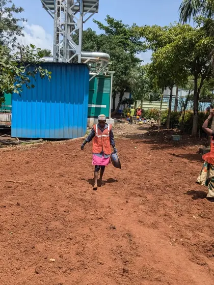 Our hardworking laborers carry soil across the site, a fundamental part of preparing the ground for planting.