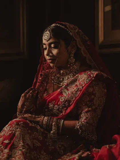 A quiet, contemplative portrait of the bride in her stunning red wedding attire.