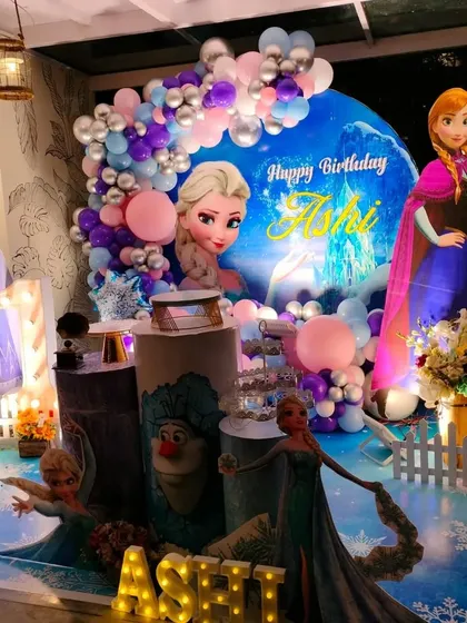 Another angle of the rustic Frozen party, highlighting the life-size Elsa and Anna cutouts.