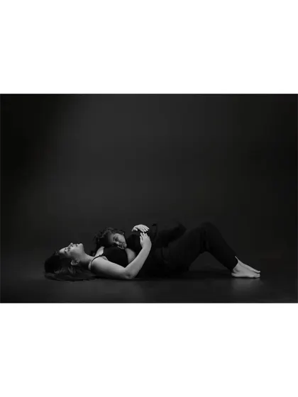 This unconventional pose, with a daughter resting on her mother's chest, is deeply moving in black and white. It speaks of trust, comfort, and the safety of a mother's love.