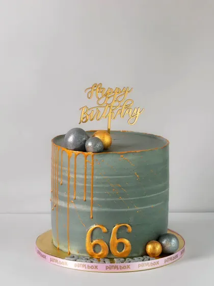 A distinguished design for a 66th birthday, this grey cake features a subtle texture, gold drip, and metallic spheres for a modern and masculine feel.