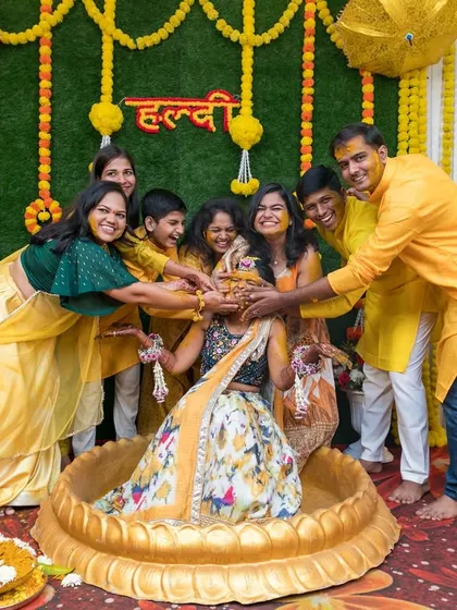 The bride surrounded by her loved ones as they apply Haldi. A moment filled with tradition, love, and laughter.