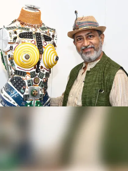 I stand beside a torso artwork built with electronic components, sharing a portrait from the collection shown during my exhibition journey.