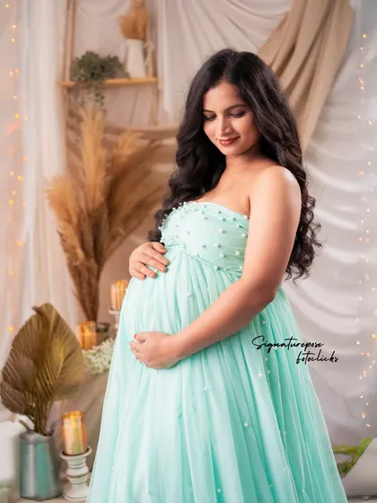 A quiet, contemplative portrait in the mint gown, set against the warm, textured boho backdrop.