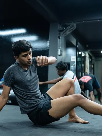A student practices a mobility drill, focusing on control and fluid movement across the mats.