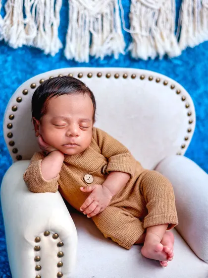 A duplicate of image 51, showing a relaxed baby in a miniature armchair.
