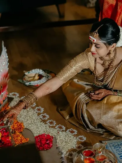 A bride participating in a puja. This quiet, candid moment shows the spiritual side of the wedding, capturing her devotion and the traditional elements of the ceremony.