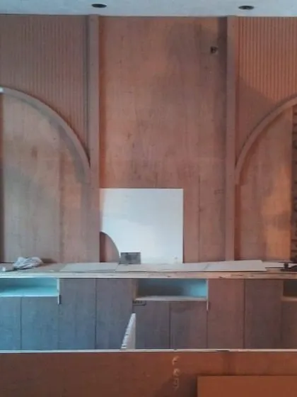 The reception back wall during the fabrication stage. Here you can see the raw plywood and framework being assembled on-site before the final finishes are applied, showing the craftsmanship behind the design.