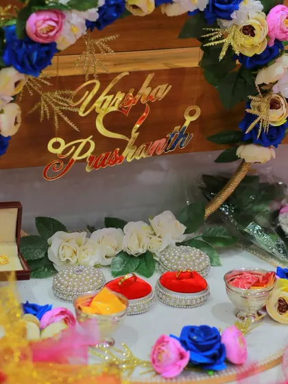 The decorative setup for an engagement or Gruha Pravesha, featuring the couple's names. I always make sure to photograph the personalized details of your event decor.
