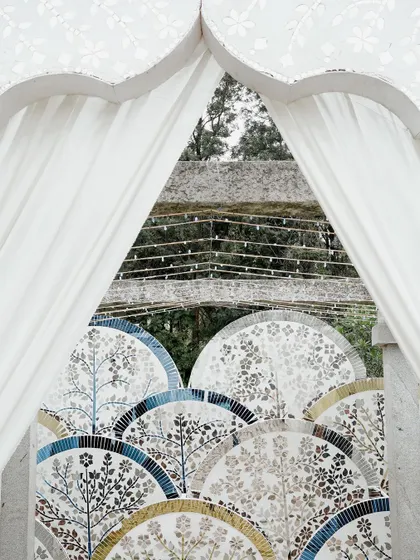 A detail of the Thikri work, seen through a draped archway. The craftsmanship is evident in the intricate patterns, each piece of mirror hand-cut and placed to create a stunning mosaic.