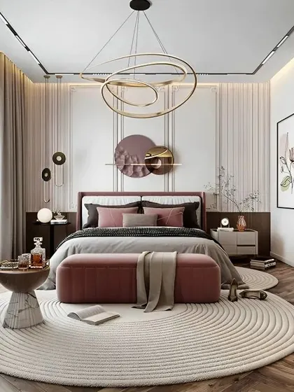 An elegant bedroom design with a modern chandelier and artistic wall decor. The combination of a plush pink bench, a circular rug, and herringbone wood flooring creates a sophisticated and stylish look.