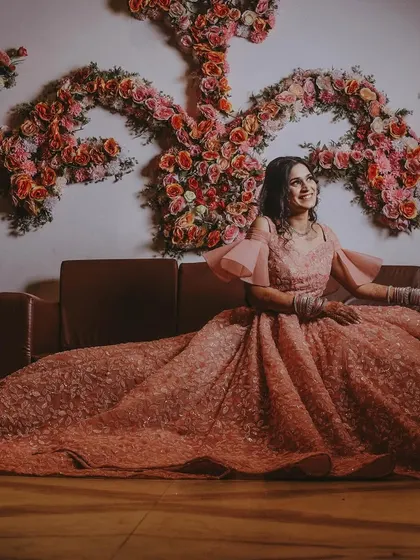 A beautiful full-length portrait of the bride-to-be, showcasing her elaborate engagement gown against a floral backdrop.