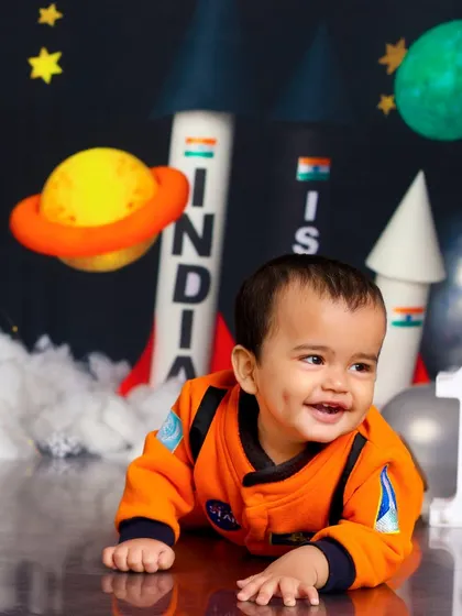 A happy little astronaut crawling among the planets. The dimples and joyful smile make this an out-of-this-world adorable photo.