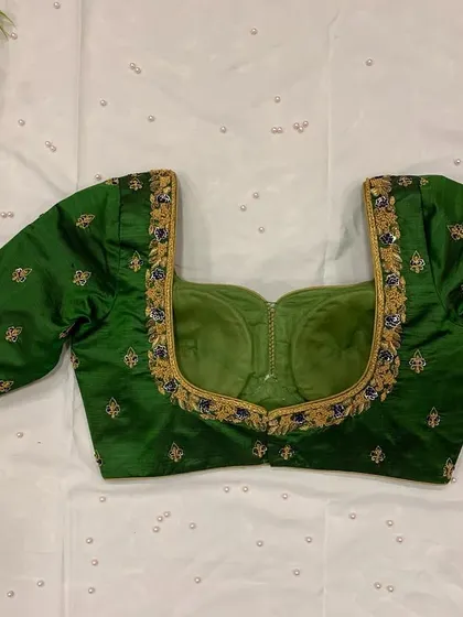 A simple and elegant green blouse with a sweetheart neckline and delicate butti embroidery.