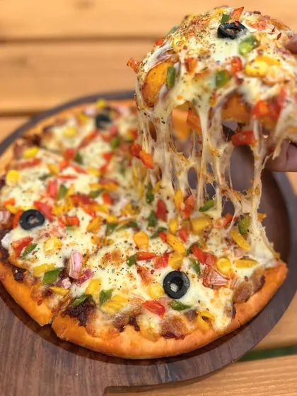 Who can resist a cheese pull like that? Our Veggie Delight Pizza is a popular choice at the Think Pawsitive Cafe.