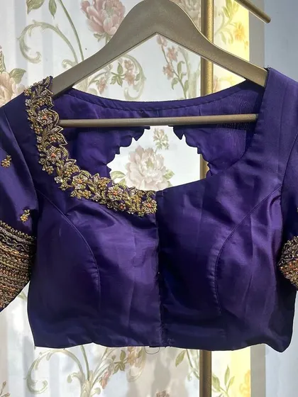 The front view of the simple purple blouse, showing the clean neckline and fit.