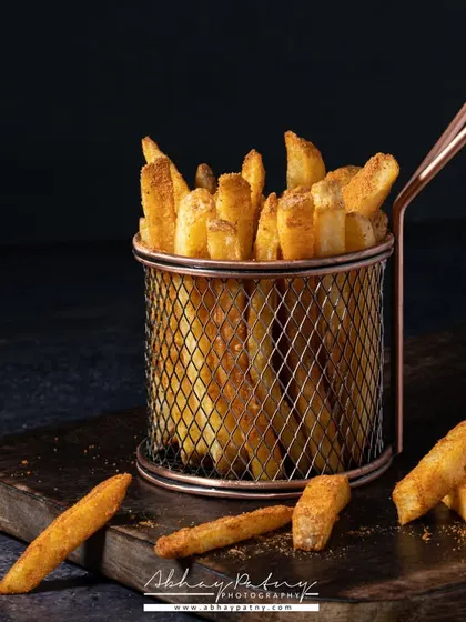 A simple basket of french fries, shot with dramatic lighting to highlight their crispy texture. This kind of iconic shot is a must-have for any cafe or QSR menu.