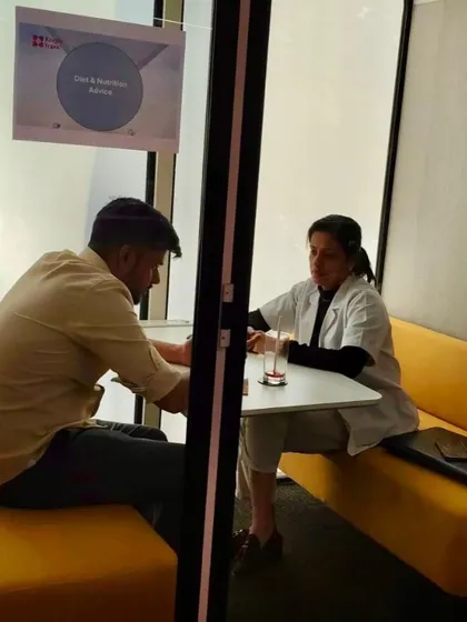 Here I am engaged in a deep conversation with an employee during a personalized diet consultation. These private sessions are crucial for addressing individual health challenges like weight management, gut issues, and eating right despite long commutes.