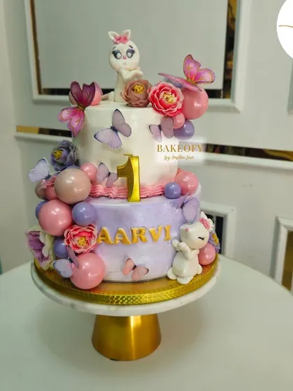 Celebrating little Aarvi’s first birthday with this adorable two-tier fresh fruit cake. It's decorated with delicate butterflies and cute fondant characters for a sweet and elegant look.