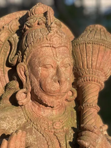 A close-up of the face of our Lord Hanuman statue, capturing the strong and devoted expression carved into the sandstone.