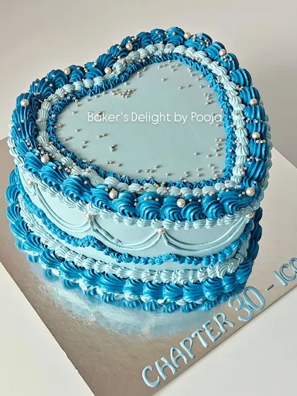 Turning 30 in style with this dreamy vintage-style heart cake. The Lambeth-style piping in shades of blue, accented with silver pearls, creates a chic and timeless look.