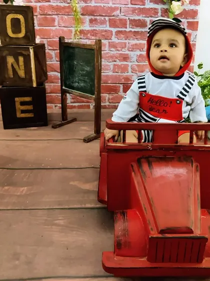 Ready to roll into year two. This image shows our red truck prop paired with the rustic schoolhouse "ONE" blocks, offering a playful and classic look for a first birthday.