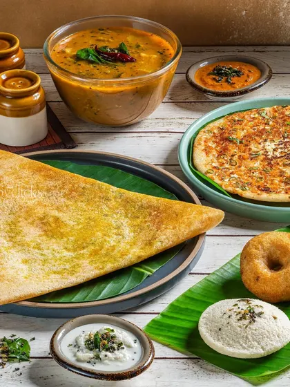 A South Indian platter featuring a dosa, idli, and vada, offering a complete meal experience in one shot.
