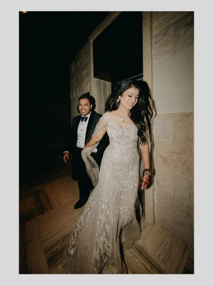 A candid shot of the couple making a grand entrance at their engagement party, full of movement and happiness.