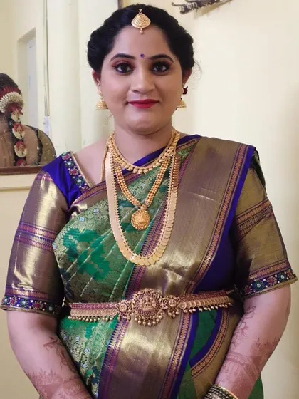 While this is a front-facing photo, the mirror provides a great view of the traditional braid adorned with flowers, showing how the entire look comes together from all angles.