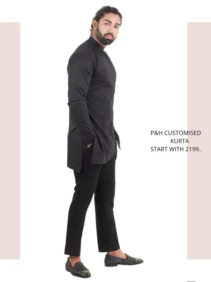 The side profile of the black asymmetrical kurta, showing its unique silhouette.